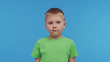 Tişörtlü mutlu gülümseyen çocuğun portresi. Stüdyodaki çekici ve etkileyici çocuk. Çocukluk kavramı.