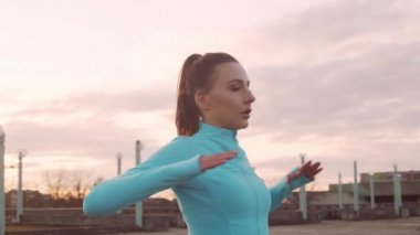 Genç, güzel ve sportif bir kadın dışarıda akşam antrenmanı yapıyor. Şehir günbatımı geçmişi. Spor ve spor konsepti.