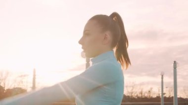 Genç, güzel ve sportif bir kadın dışarıda akşam antrenmanı yapıyor. Şehir günbatımı geçmişi. Spor ve spor konsepti.