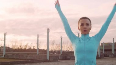 Genç, güzel ve sportif bir kadın dışarıda akşam antrenmanı yapıyor. Şehir günbatımı geçmişi. Spor ve spor konsepti.