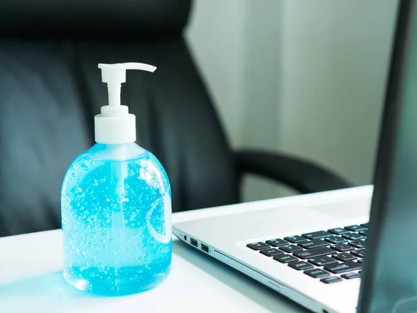 Una Botella Gel Alcohol Azul Con Portátil Está Frente Fondo —  Fotos de Stock