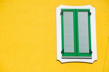İtalya 'nın sarı duvarında çizgili tek pencere.