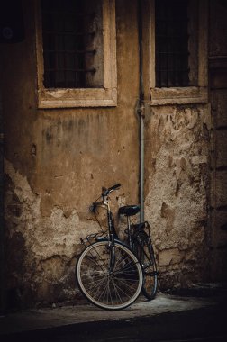 Verona 'daki eski kahverengi duvarın yanındaki bisiklet.