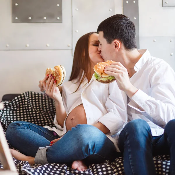 Pregnant couple eating fastfood — Stock Photo, Image