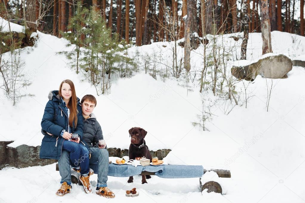 Couple and labrador dog in winter nature