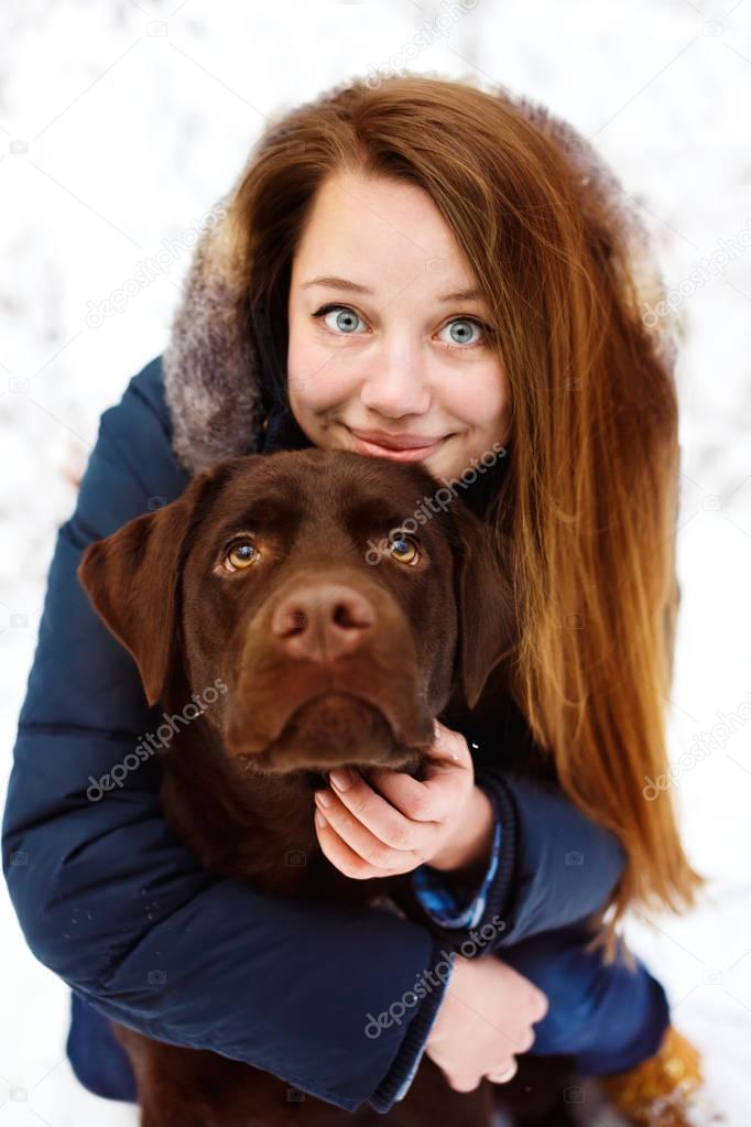 Woman with labrador dog in winter forest