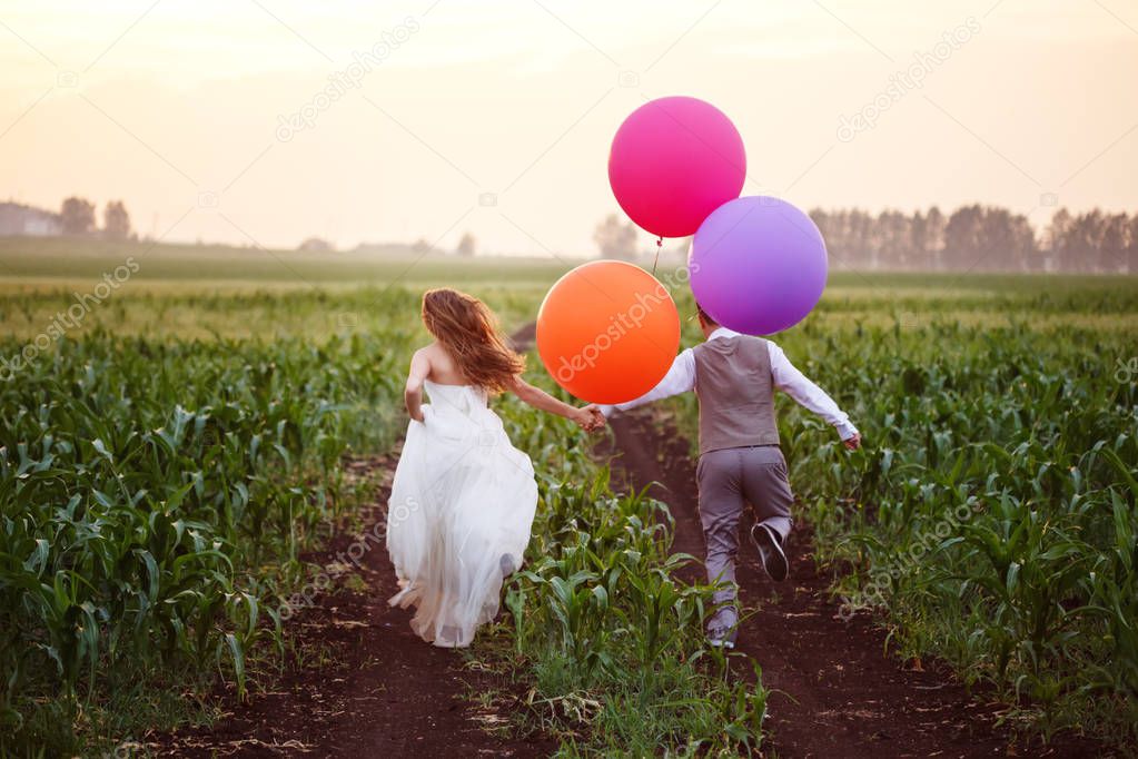 Wedding couple at field with balloons