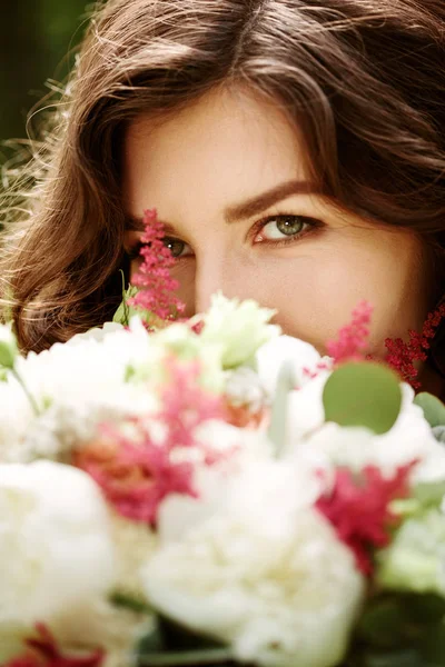 Piękna kobieta za kwiaty — Zdjęcie stockowe