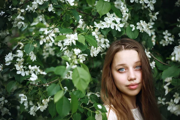 Ung kvinna i blommande våren träd — Stockfoto