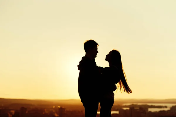 Pareja abrazándose en un techo al atardecer — Foto de Stock