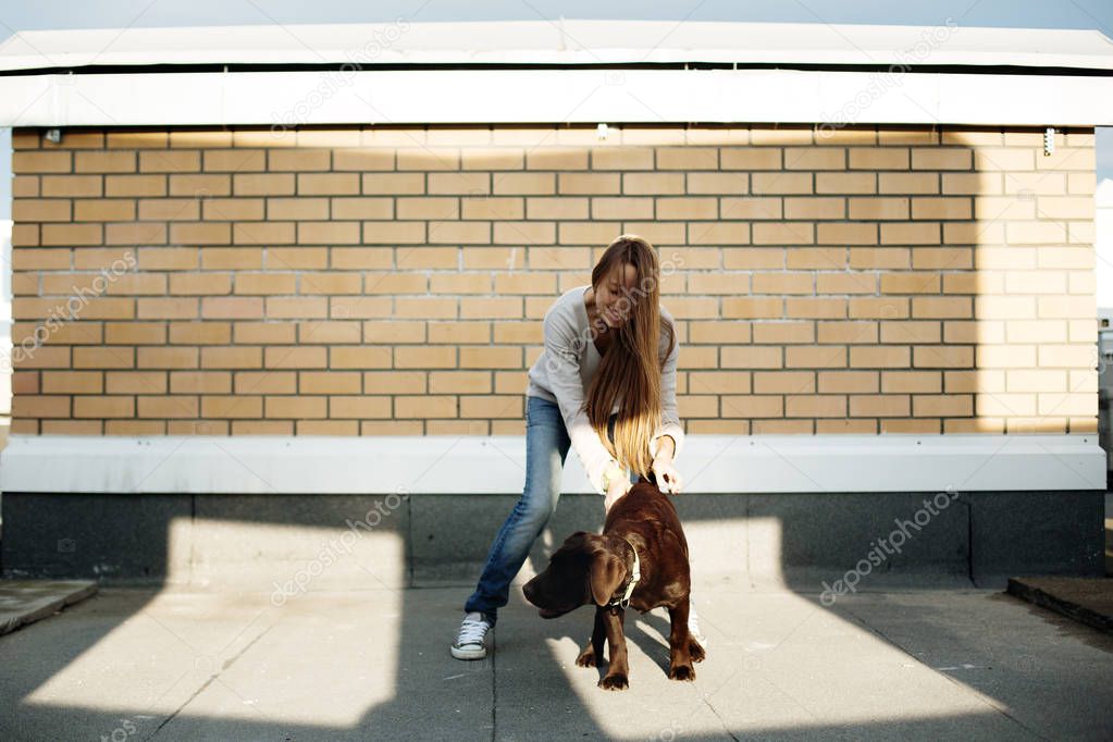 Young woman playing with her dog labrador
