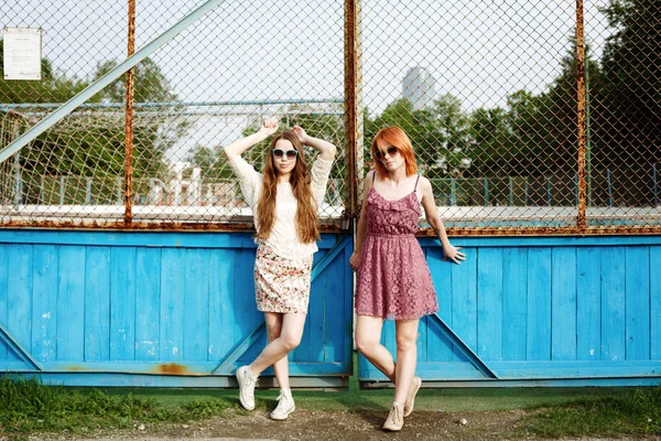 Две молодые женщины позируют возле двора — стоковое фото