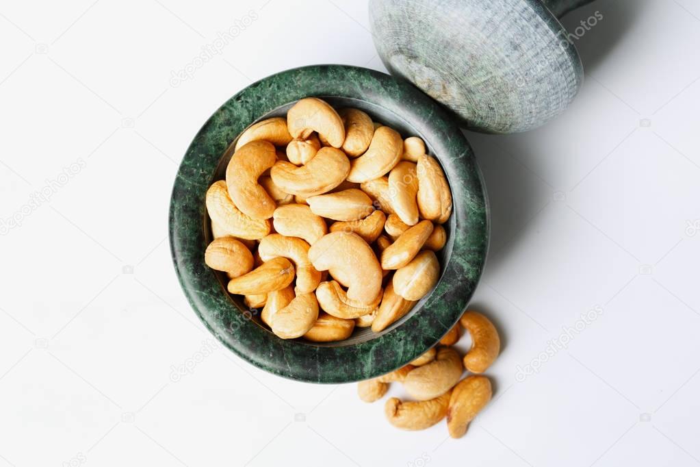 Roasted cashew nuts in a marble mortar 