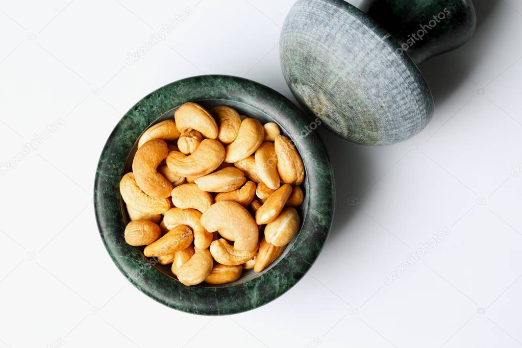 Roasted cashew nuts in a marble mortar 