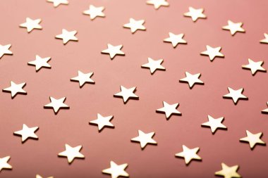 Tozlu pembe arka planda altın yıldızlı şenlikli kompozisyon mevcut, seçici odak