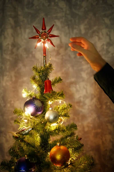 Main Humaine Décorant Sapin Noël Avec Haut Étoilé Lumières Festives — Photo