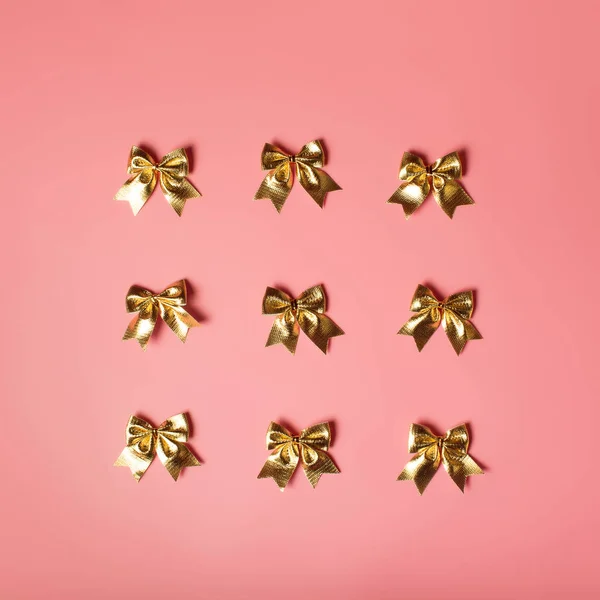 Розовый фон праздника с золотыми луками — стоковое фото