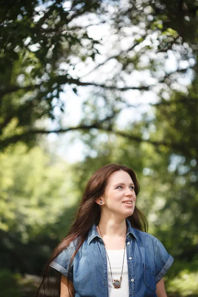 Junge lächelnde brünette Frau, die draußen geht — Stockfoto