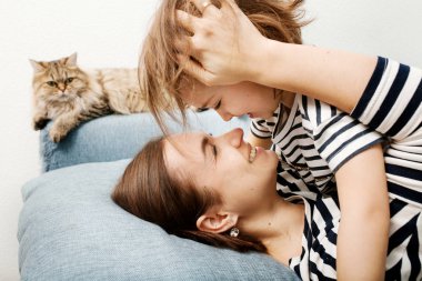 Güzel gülümseyen anne, küçük tatlı kızına sarılıyor.