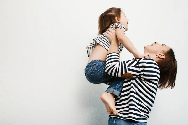 Mãe feliz segurando criança adorável em suas mãos e rindo — Fotografia de Stock