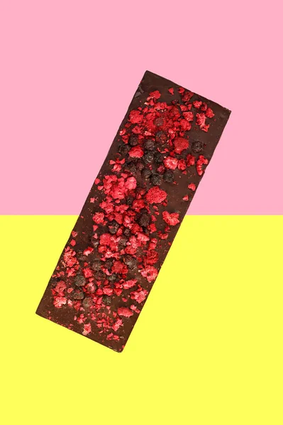 Kurutulmuş kırmızı dutlu çikolata, açık pembe yarı sarı arka plan. — Stok fotoğraf