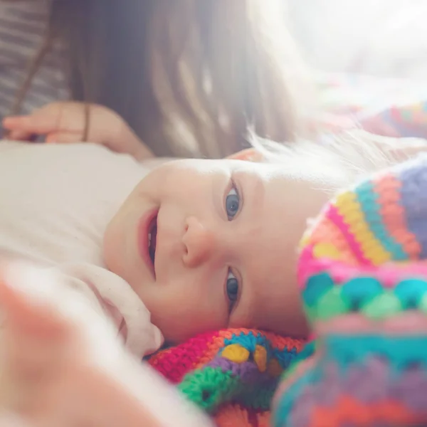 Close-up portrait of cute little infant girl lying on bed in mor — Stockfoto