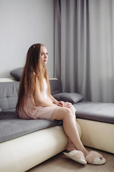 Piękna Spokojna Kobieta Długimi Włosami Różowej Tkaninie Domowej Siedzi Sama — Zdjęcie stockowe