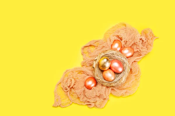 色彩艳丽的东方假日背景 鸟巢中的彩蛋和金蛋覆盖在黄色之上 顶视图 时髦的概念与复制空间 — 图库照片
