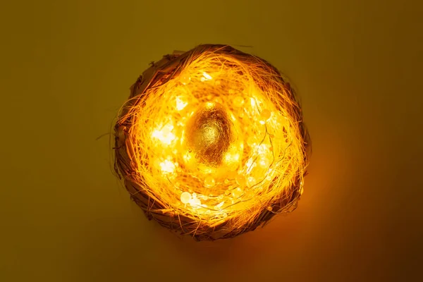 Yuvadaki Altın Yumurta Pastel Arka Planda Işıklar Gizemli Paskalya Konsepti — Stok fotoğraf