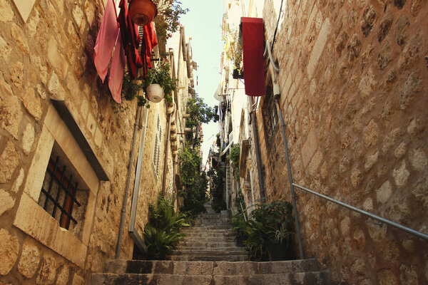 Narrow street with stone stairs and pots with flowers in Dubrovnik, Croatia, travel destinations