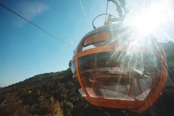 Round cable car going to mountain in sun light