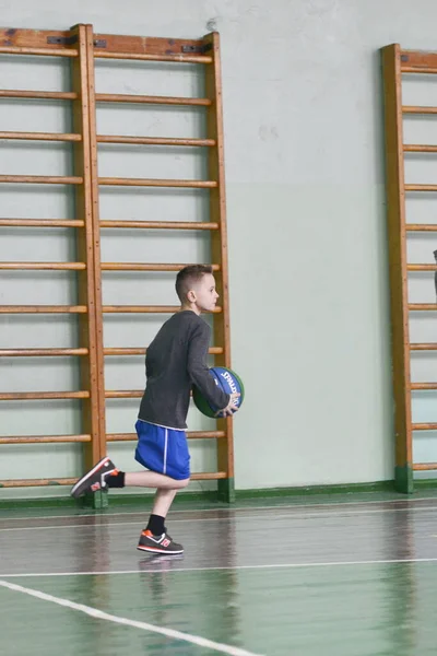 Un chico juega baloncesto en el gimnasio. Un joven atleta. Salud de los niños. Estilo de vida saludable en la infancia . —  Fotos de Stock