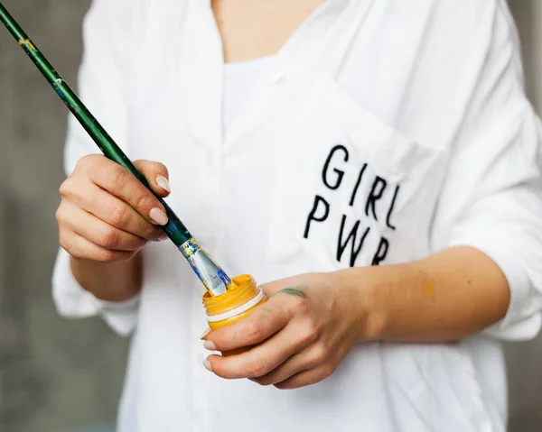 Sanatın kadın gücü. Kız elinde fırça ve boya tutuyor. Sanatçı ilham alır.. — Stok fotoğraf