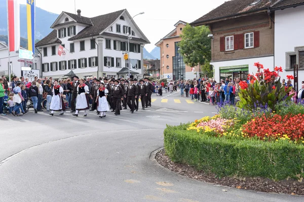 Les gens portant des vêtements traditionnels et chantant dans un défilé — Photo