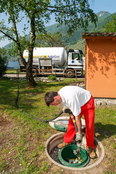 Travailleur faisant l'approvisionnement en gaz sur un réservoir dans le jardin — Photo