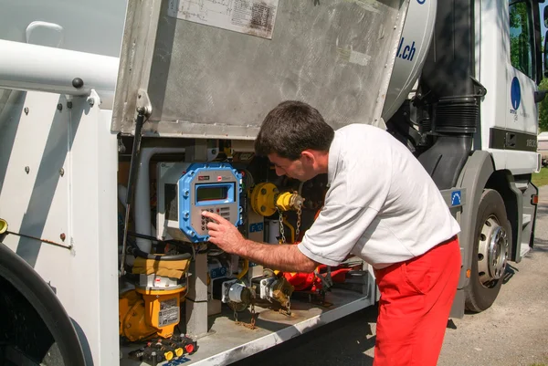 Travailleur faisant l'approvisionnement en gaz sur un réservoir dans le jardin — Photo