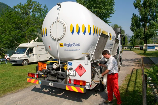 Trabajador haciendo suministro de gas en un tanque en el jardín — Foto de Stock