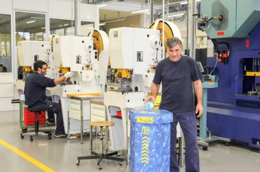 Sanayi salonunda çalışan erkekler