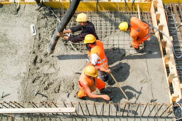 Les travailleurs de la rue versent du ciment avec une pompe dans une autoroute constru — Photo