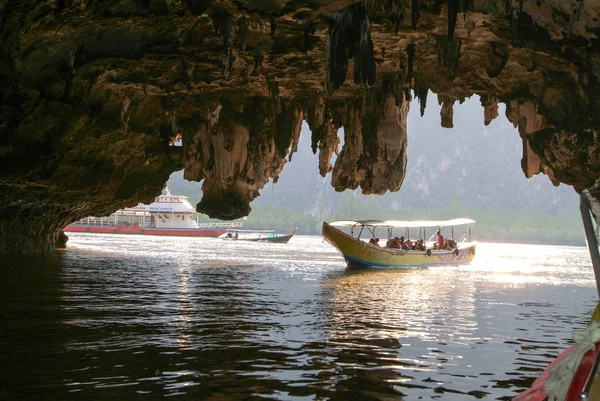 Mensen op een toeristische boot die via een grot loopt — Stockfoto