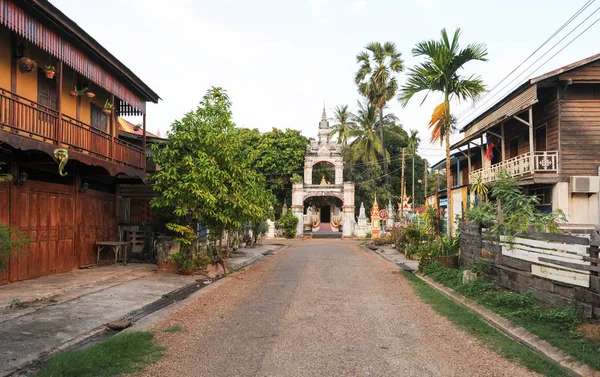 Straße mit Kolonialhäusern und wat sainyaphum Tempel in der Savanne — Stockfoto