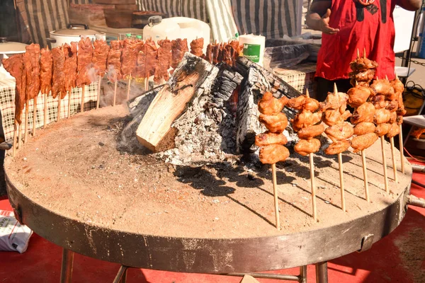 Brochetas de carne a la parrilla cocinadas en el fuego en el festival de comida callejera —  Fotos de Stock