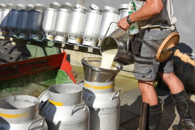 Süt tankları bir çiftlik evinde içine dökme işçi