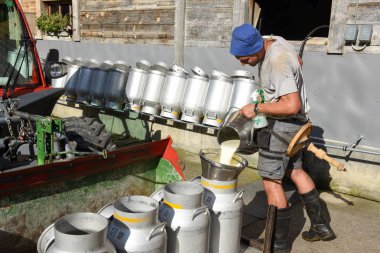 Süt tankları bir çiftlik evinde içine dökme işçi