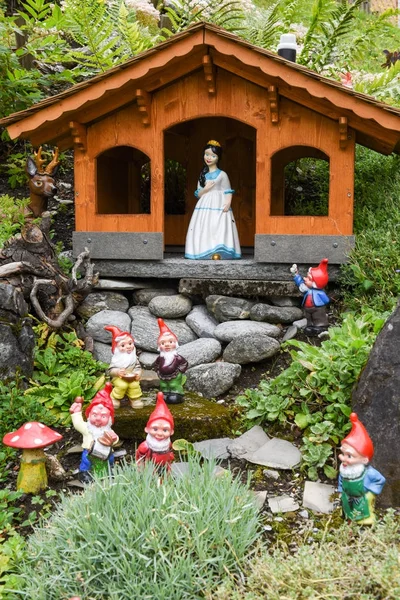 Blancanieves y enanos en un jardín de una casa —  Fotos de Stock