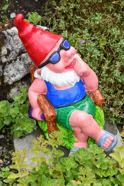 Kert gnome ül egy széken, egy kert — Stock Fotó