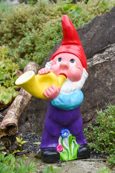 Garden gnome grając w róg w ogrodzie — Zdjęcie stockowe