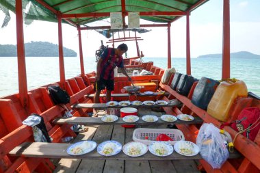 Adam Öğle Yemeği Teknede turistler için hazırlanıyor.