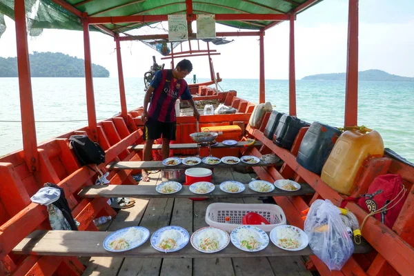 彼のボートに乗って観光客の昼食を準備する男 — ストック写真