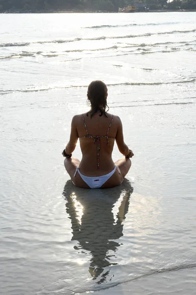 Fille qui pratique le yoga sur la plage — Photo